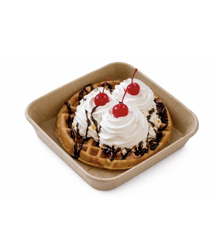Waffle sundae topped with whipped cream and cherries